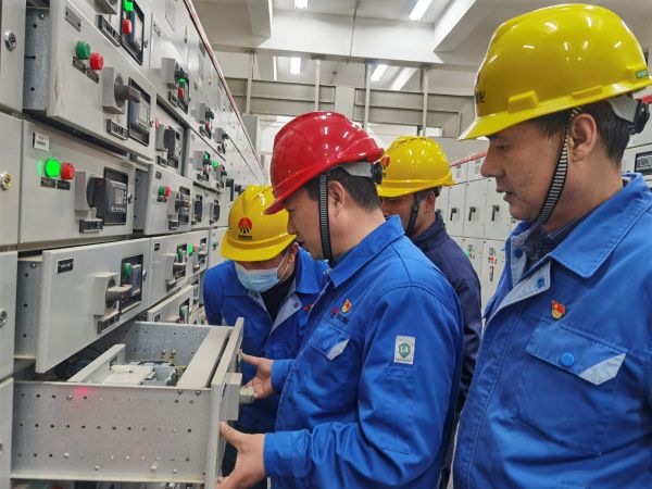 3月16日，對標(biāo)交流現(xiàn)場，大家圍在一起對配電室開關(guān)柜查找差距與優(yōu)勢.jpg