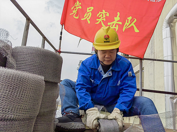 5月10日中午，在動力車間三期工藝除氧器平臺上，黨員突擊隊隊長李鑫正在纏繞新填料.jpg