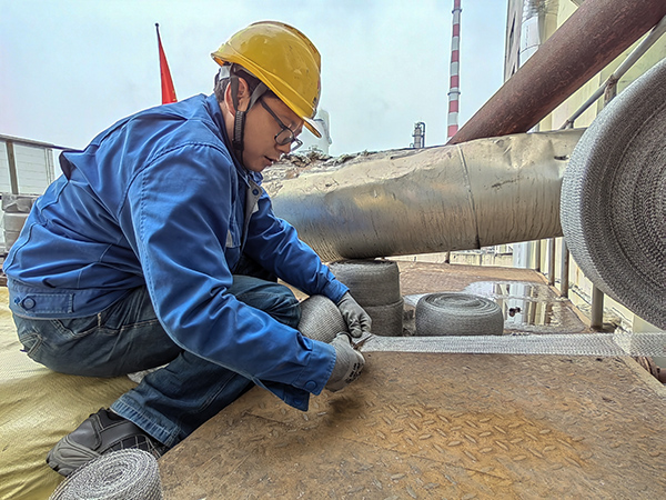 5月10日中午，在動力車間三期工藝除氧器平臺上，黨員突擊隊隊員劉瑞斌正在纏繞新填料.jpg