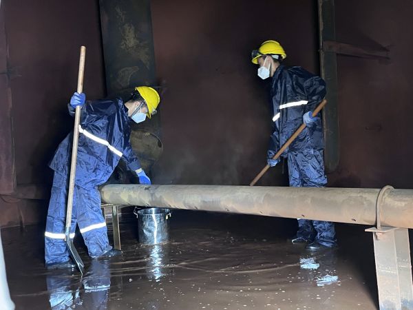 將熱水槽底部污水鏟倒廢桶中，用廢桶搬運出去.jpg