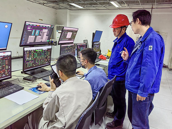5月13日，動(dòng)力車(chē)間三期鍋爐控制室，DCS改造工藝、儀表、電氣等部門(mén)聯(lián)合調(diào)試，車(chē)間主任姜軍虎與技術(shù)員畢加佳查看調(diào)試過(guò)程.jpg