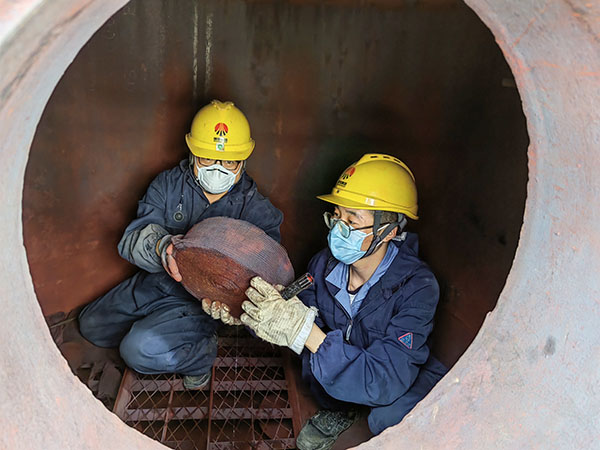 5月11日，動(dòng)力車(chē)間三期工藝除氧器內(nèi)部，黨員突擊隊(duì)隊(duì)員劉瑞斌和李震正在清理舊填料.jpg
