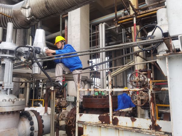 氣化爐上，柳曦、徐騰飛冒雨調(diào)試氣化爐電動(dòng)閥.jpg