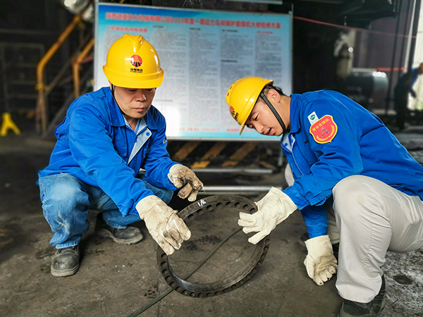 圖三：12日下午14時，在一期磨煤機(jī)廠房，陜西省技術(shù)能手姬霄給青工張跟潮講解磨煤機(jī)搖臂曲拐內(nèi)環(huán)及動作原理。.jpg